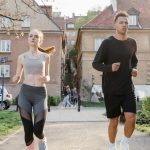 Two young adults jogging on a city path, showcasing an active lifestyle in an urban environment.