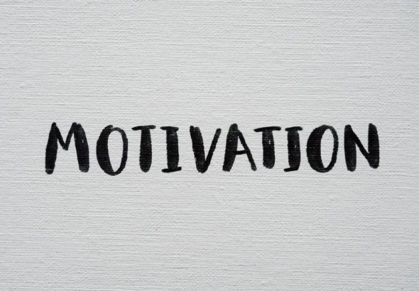 Inspirational word 'Motivation' in black on a white textured canvas background.