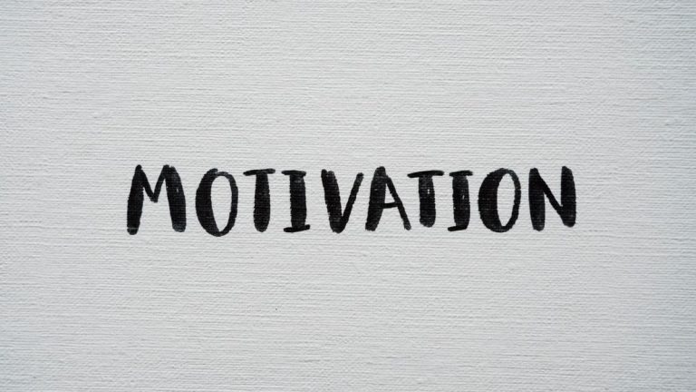 Inspirational word 'Motivation' in black on a white textured canvas background.